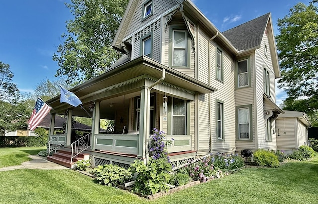 403 E Hickory St, Fairbury, IL 61739 - view of side of home with a porch, a lawn, and roof with shingles