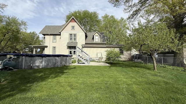 403 E Hickory St, Fairbury, IL 61739 - back of property featuring a covered pool, a shingled roof, and a patio area