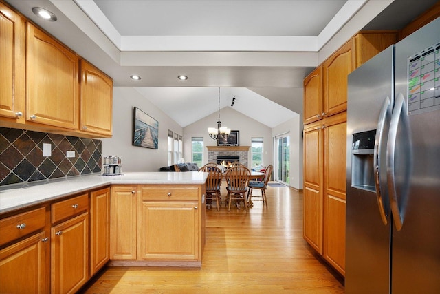 1508 Parkside Dr, Plainfield, IL 60586 - kitchen with stainless steel fridge, light wood-style flooring, a peninsula, vaulted ceiling, and open floor plan