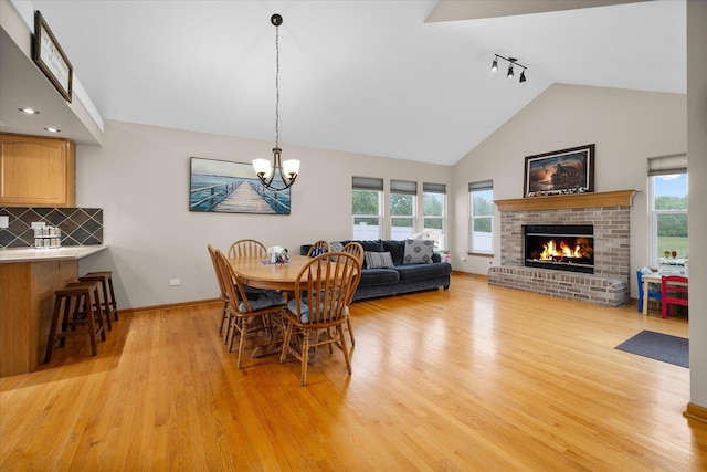 1508 Parkside Dr, Plainfield, IL 60586 - dining space with track lighting, light wood-type flooring, plenty of natural light, a fireplace, and high vaulted ceiling