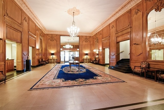 5555 N Sheridan Rd Unit 308, Chicago, IL 60640 - community lobby featuring stairs, ornamental molding, wooden walls, and a decorative wall
