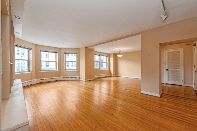 5555 N Sheridan Rd Unit 308, Chicago, IL 60640 - unfurnished living room featuring light wood-style flooring, a baseboard radiator, and baseboards