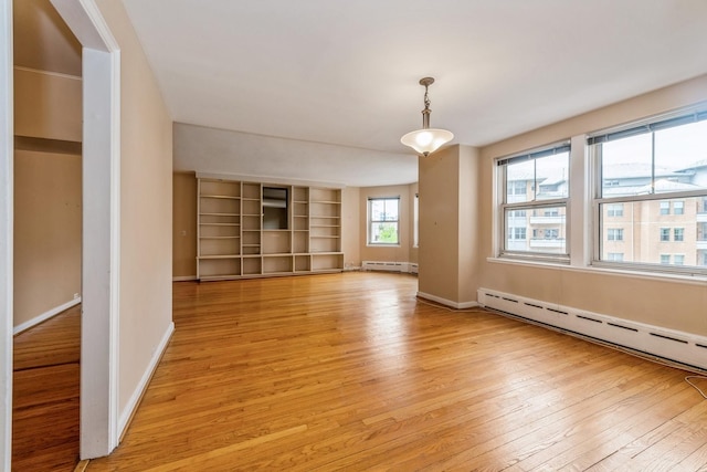 5555 N Sheridan Rd Unit 308, Chicago, IL 60640 - unfurnished room with baseboard heating, light wood finished floors, and baseboards