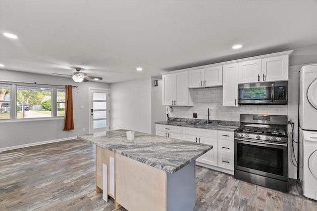 1011 Cypress Ln, Joliet, IL 60435 - kitchen featuring appliances with stainless steel finishes, stacked washer / dryer, backsplash, a center island, and light wood finished floors