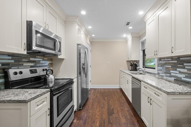1000 Meadow Rd, Northbrook, IL 60062 - kitchen featuring appliances with stainless steel finishes, a sink, baseboards, white cabinetry, and decorative backsplash