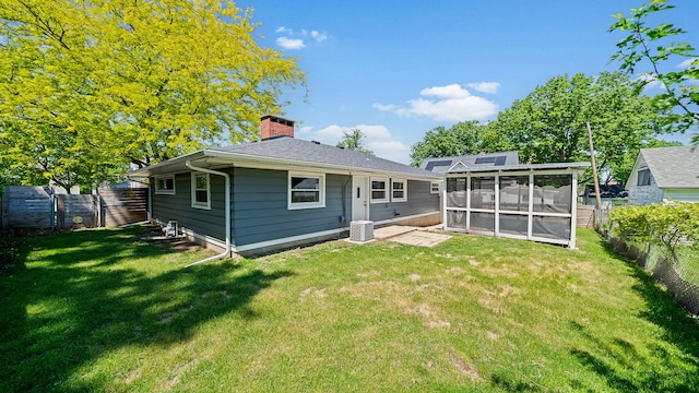 522 Division St, Pecatonica, IL 61063 - rear view of house featuring a sunroom, a chimney, and central AC