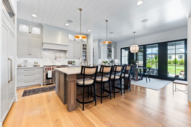 5N257 Switchgrass Ln, Saint Charles, IL 60175 - kitchen featuring premium stove, custom exhaust hood, light countertops, a kitchen island with sink, and light wood-style floors