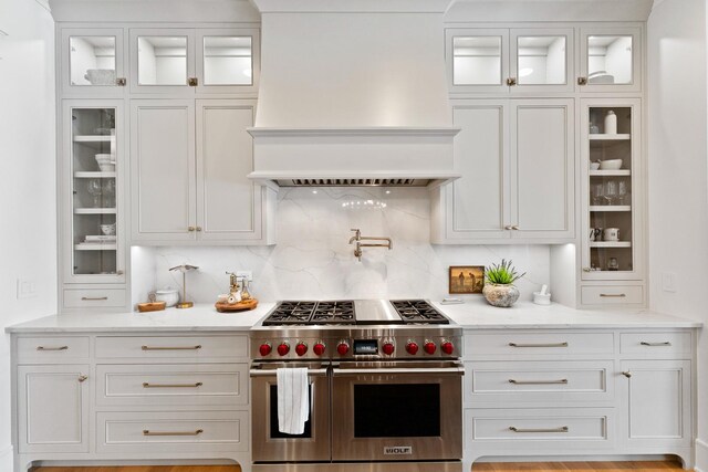 5N257 Switchgrass Ln, Saint Charles, IL 60175 - kitchen with double oven range, premium range hood, white cabinets, and light stone counters