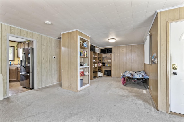 8 Sparrow Rd, Carpentersville, IL 60110 - basement with stainless steel refrigerator with ice dispenser, wooden walls, crown molding, and light colored carpet
