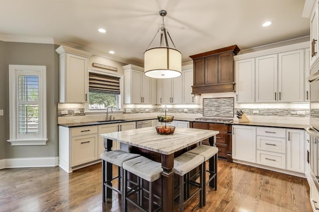 212 S Wa Pella Ave, Mount Prospect, IL 60056 - kitchen with a sink, a kitchen breakfast bar, decorative backsplash, wood finished floors, and crown molding