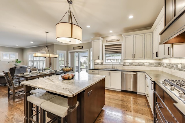 212 S Wa Pella Ave, Mount Prospect, IL 60056 - kitchen featuring appliances with stainless steel finishes, a sink, custom exhaust hood, a kitchen island, and a kitchen bar
