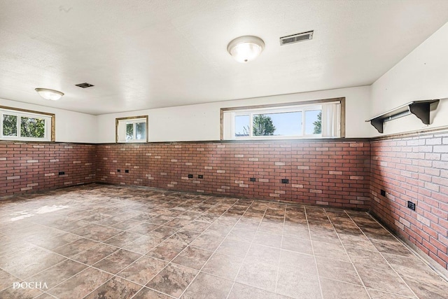 9446 Magnolia Ave, Mokena, IL 60448 - unfurnished room featuring brick wall and plenty of natural light