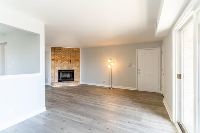 6154 W 63rd St Unit 3W, Chicago, IL 60638 - unfurnished living room with light wood finished floors, a brick fireplace, and baseboards