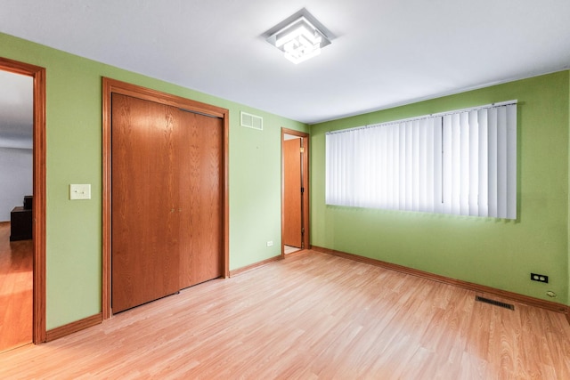 1018 Brighton Ct, Schaumburg, IL 60193 - unfurnished bedroom with light wood-type flooring, a closet, and baseboards