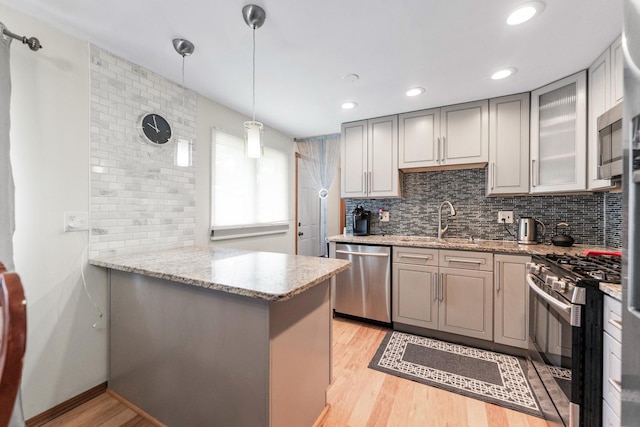 1018 Brighton Ct, Schaumburg, IL 60193 - kitchen featuring stainless steel appliances, a sink, gray cabinetry, light wood finished floors, and backsplash