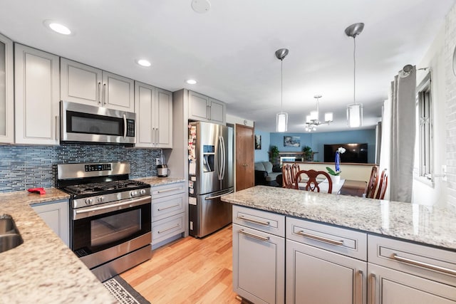 1018 Brighton Ct, Schaumburg, IL 60193 - kitchen featuring appliances with stainless steel finishes, gray cabinets, light wood-style flooring, decorative backsplash, and decorative light fixtures