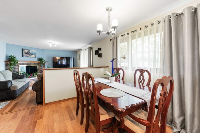 1018 Brighton Ct, Schaumburg, IL 60193 - dining area featuring light wood-type flooring, a chandelier, and a fireplace