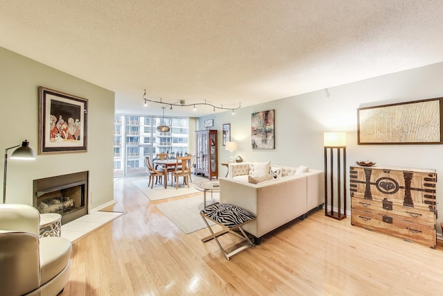 1580 Sherman Ave Unit 1006, Evanston, IL 60201 - living area featuring light wood-style floors, rail lighting, a fireplace, and a textured ceiling