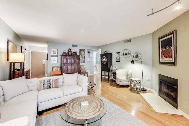 1580 Sherman Ave Unit 1006, Evanston, IL 60201 - living room with wood finished floors, a tiled fireplace, and baseboards