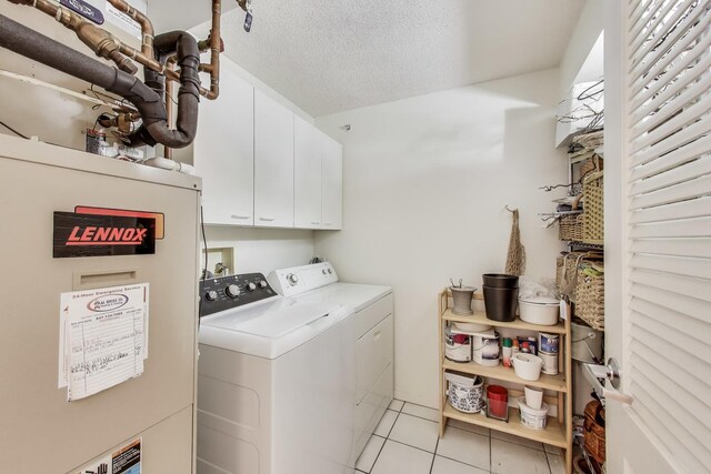 1580 Sherman Ave Unit 1006, Evanston, IL 60201 - washroom featuring cabinet space, washing machine and clothes dryer, light tile patterned floors, water heater, and a textured ceiling