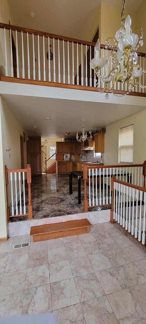 6238 S Kolmar Ave, Chicago, IL 60629 - stairway with a towering ceiling, marble look tile flooring, and a chandelier