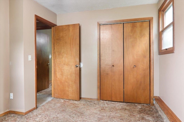 1212 Colton Ave, Bloomington, IL 61701 - unfurnished bedroom featuring a closet, carpet floors, and baseboards
