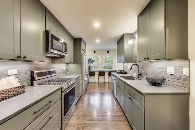 502 S William St, Mount Prospect, IL 60056 - kitchen with stainless steel appliances, a sink, backsplash, and light wood-style floors