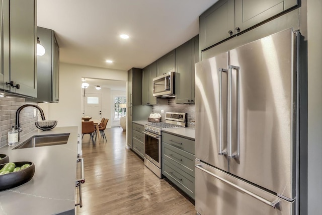 502 S William St, Mount Prospect, IL 60056 - kitchen featuring stainless steel appliances, a sink, decorative backsplash, light wood-style floors, and recessed lighting