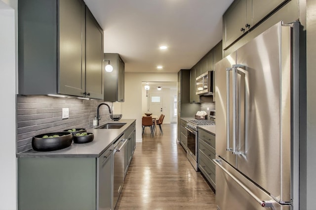 502 S William St, Mount Prospect, IL 60056 - kitchen featuring premium appliances, a sink, wood finished floors, decorative backsplash, and gray cabinetry