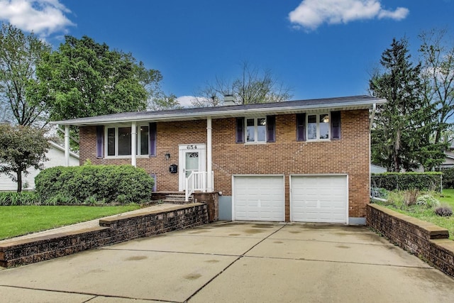 654 N Robinson Dr, Palatine, IL 60074 - bi-level home featuring a garage, driveway, brick siding, and a chimney