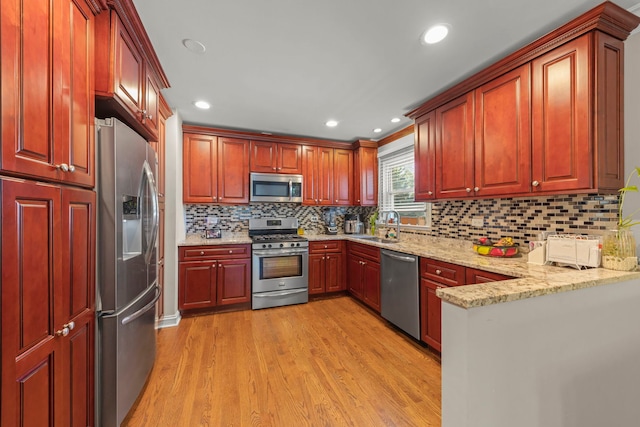 573 Maple Ave, Lisle, IL 60532 - kitchen with appliances with stainless steel finishes, light wood-style flooring, a sink, light stone counters, and tasteful backsplash