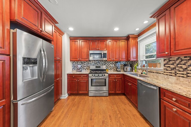 573 Maple Ave, Lisle, IL 60532 - kitchen featuring appliances with stainless steel finishes, a sink, light wood-type flooring, light stone counters, and tasteful backsplash