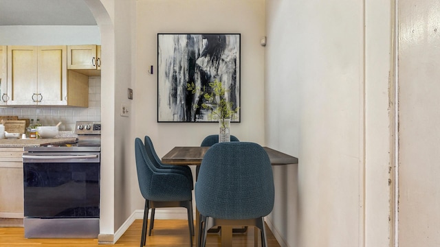 7360 N Damen Ave Unit 1S, Chicago, IL 60645 - dining space with arched walkways, wood finished floors, and baseboards