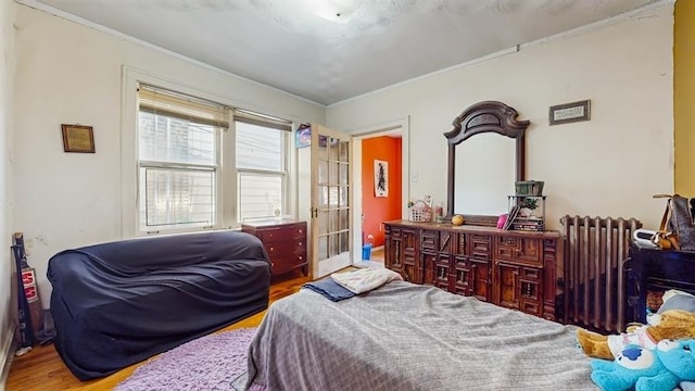 7360 N Damen Ave Unit 1S, Chicago, IL 60645 - bedroom featuring radiator, wood finished floors, ornamental molding, and french doors