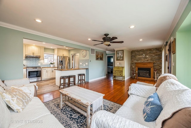 8349 W 82nd St, Justice, IL 60458 - living room with crown molding, a fireplace, light wood finished floors, a ceiling fan, and recessed lighting