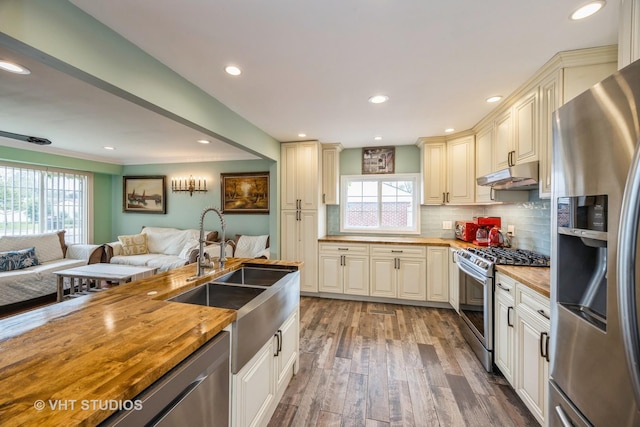 8349 W 82nd St, Justice, IL 60458 - kitchen featuring stainless steel appliances, under cabinet range hood, wooden counters, healthy amount of natural light, and recessed lighting