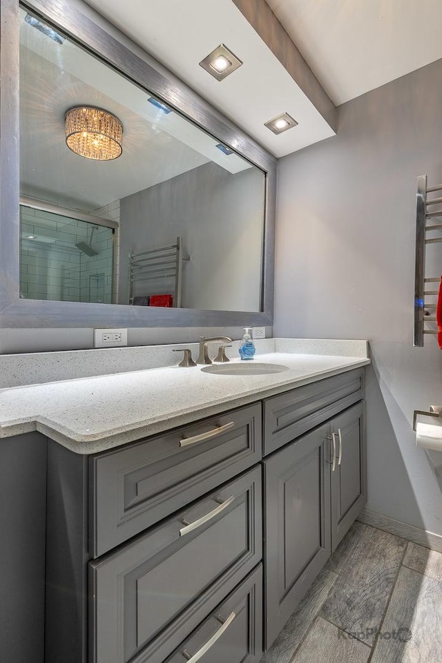 5455 N Sheridan Rd Unit 3006, Chicago, IL 60640 - bathroom with vanity, wood finished floors, tiled shower, a towel warmer, and baseboards