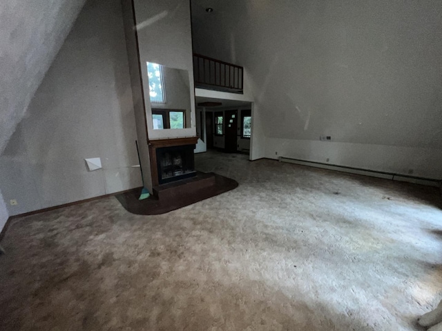 307 Northern Oaks Dr, Groveland, IL 61535 - unfurnished living room with carpet, lofted ceiling, a fireplace with raised hearth, and baseboards