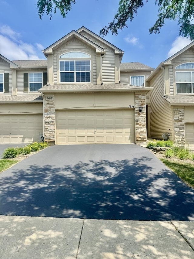 1676 Fredericksburg Ln, Aurora, IL 60503 - view of front of property with stone siding, an attached garage, and driveway