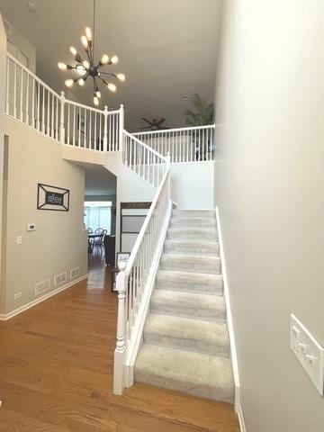 1676 Fredericksburg Ln, Aurora, IL 60503 - staircase featuring wood finished floors, a towering ceiling, a chandelier, and a ceiling fan