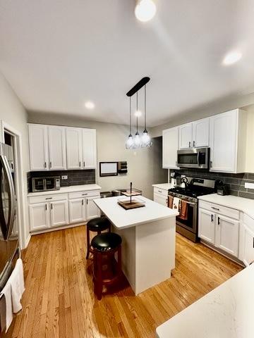 1676 Fredericksburg Ln, Aurora, IL 60503 - kitchen with stainless steel appliances, backsplash, and white cabinets