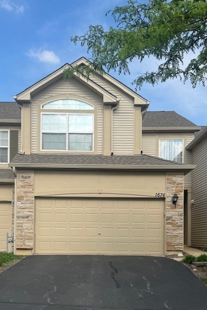 1676 Fredericksburg Ln, Aurora, IL 60503 - view of front facade with stone siding, asphalt driveway, and a garage