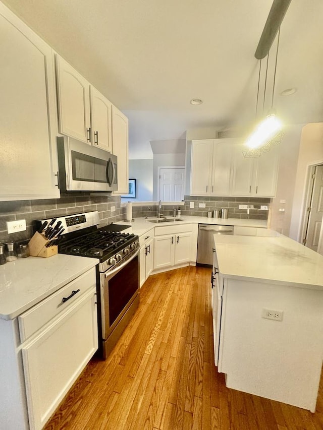 1676 Fredericksburg Ln, Aurora, IL 60503 - kitchen featuring appliances with stainless steel finishes, light countertops, wood finished floors, and white cabinetry