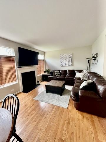 1676 Fredericksburg Ln, Aurora, IL 60503 - living area with light wood-style floors and a fireplace with flush hearth