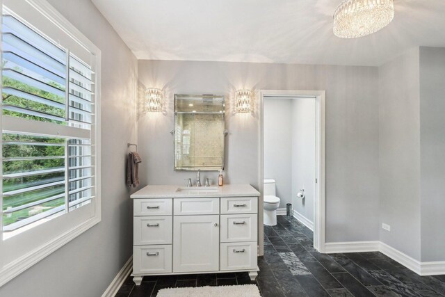 2902 Pleasant Dr, Mchenry, IL 60051 - bathroom featuring a chandelier, toilet, vanity, and baseboards