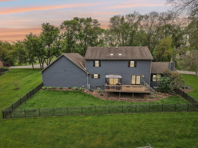 2902 Pleasant Dr, Mchenry, IL 60051 - back of property at dusk featuring a wooden deck, view of wooded area, roof with shingles, and a chimney