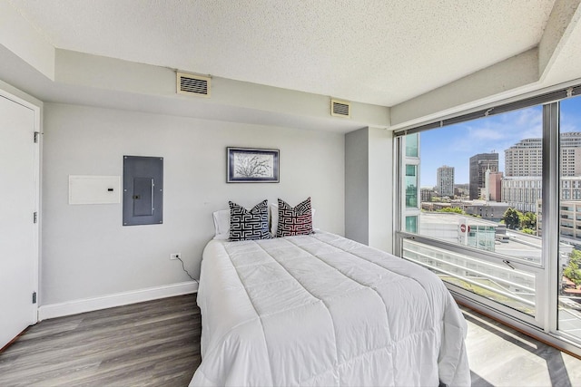 1720 Maple Ave Unit 1270, Evanston, IL 60201 - bedroom with electric panel, wood finished floors, a view of city, baseboards, and a textured ceiling