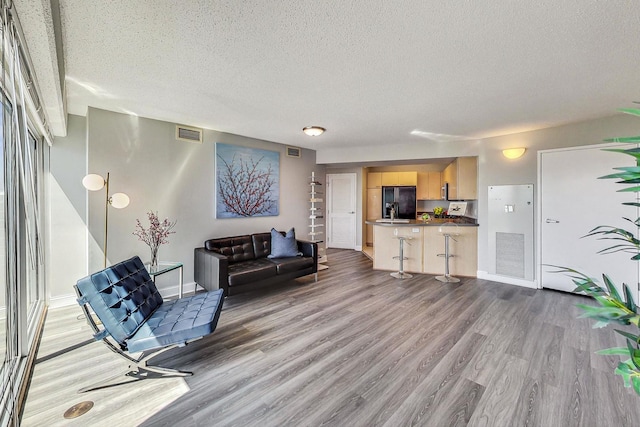 1720 Maple Ave Unit 1270, Evanston, IL 60201 - living room with a textured ceiling, light wood finished floors, and baseboards