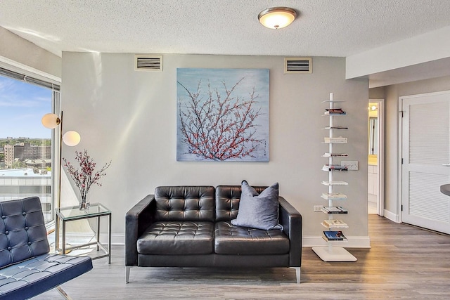 1720 Maple Ave Unit 1270, Evanston, IL 60201 - living room with wood finished floors, baseboards, and a textured ceiling