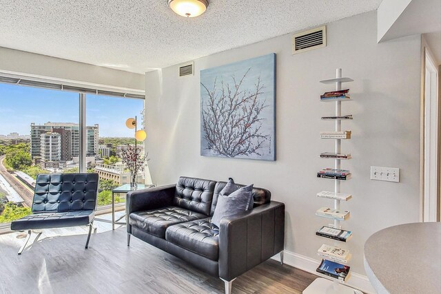 1720 Maple Ave Unit 1270, Evanston, IL 60201 - living area with wood finished floors, plenty of natural light, a textured ceiling, a city view, and baseboards